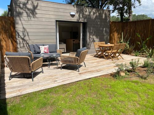 une terrasse en bois avec des chaises et une table. dans l'établissement Perla Bianca, à Bonifacio