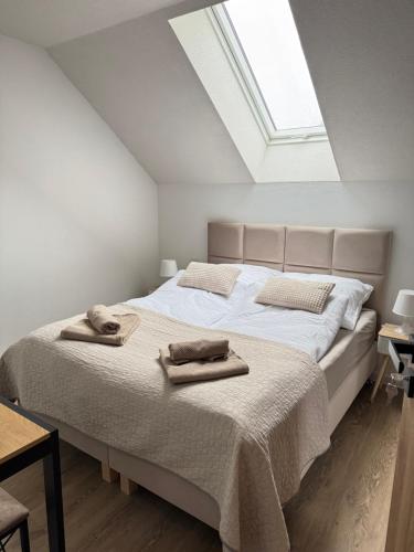 a bedroom with a bed with two towels on it at Apartament PLAY in Pietrzykowice