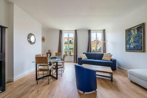 un salon avec un canapé bleu et une table dans l'établissement Elegant et lumineux 3 pieces Avenue Jean Medecin, à Nice