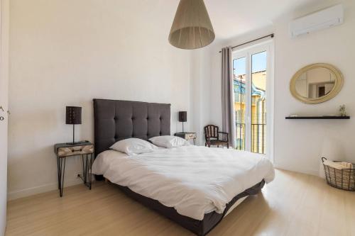 une chambre avec un grand lit et une grande fenêtre dans l'établissement Elegant et lumineux 3 pieces Avenue Jean Medecin, à Nice