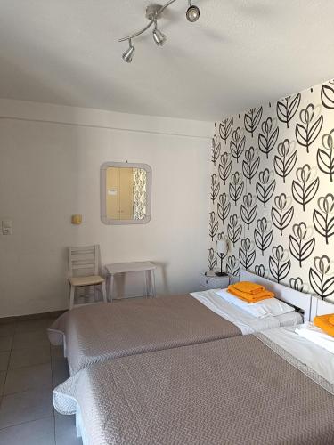 a bedroom with two beds and a wall with a mirror at Meltemi in Vourkarion