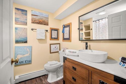 a bathroom with a sink and a toilet and a mirror at Walk to Pond 2 Min Drive to Beach in Eastham