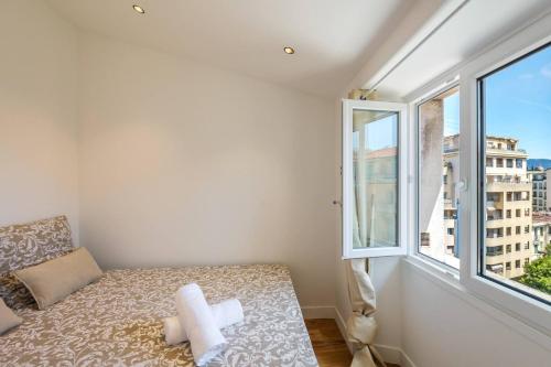 une petite pièce avec un lit et une fenêtre dans l'établissement Magnifique studio boulevard Gambetta - B, à Nice