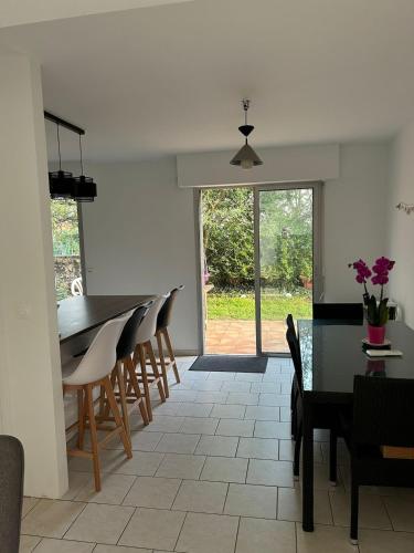une salle à manger et une cuisine avec une table et des chaises dans l'établissement Maison au calme avec jardin, à Bénesse-Maremne