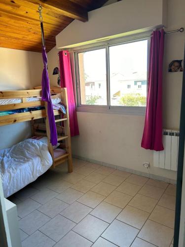 une chambre avec lits superposés et une fenêtre dans l'établissement Maison au calme avec jardin, à Bénesse-Maremne