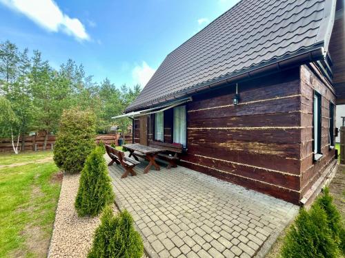 a log cabin with a picnic bench next to it at Wigierska Osada 2 in Danowskie