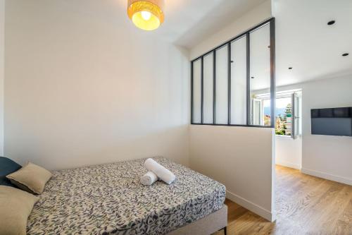 une chambre avec un lit et une grande fenêtre dans l'établissement Magnifique studio boulevard gambetta - A, à Nice