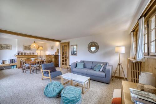 un salon avec un canapé bleu et une table dans l'établissement Megève 4 seasons apartment, à Megève