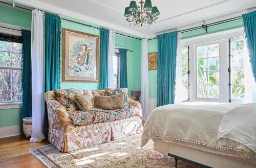 a bedroom with a couch and a bed and windows at Hollywood Home in Los Angeles