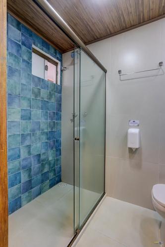 a bathroom with a glass shower with a toilet at Hotel Praia do Sol in Ilhéus