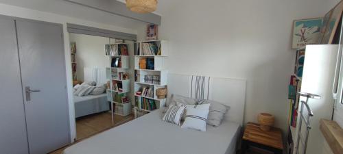 a white room with a bed and a mirror at maison Saint Jean de Luz 6 personnes piscine et jacuzzi in Saint-Jean-de-Luz