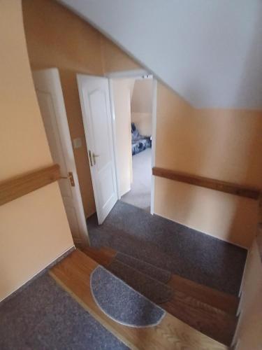 an attic room with a hallway with two white doors at Willa na Kaszubach z wlasna linia brzegowa nad jeziorem 4 sypialnie ,ryby,grzyby in Zgorzałe