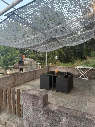 a patio with a black table and a net at Maison T3 Bastia Sud, Casamozza in Monte