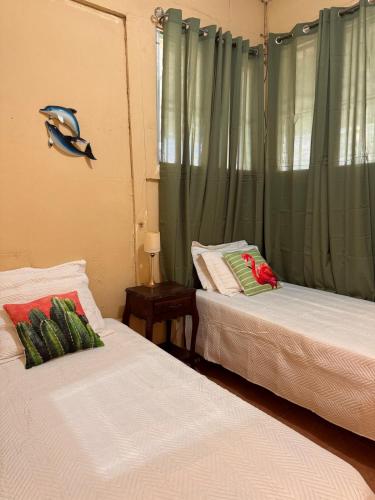 two beds in a room with a fish on the wall at Sunset House in Transito
