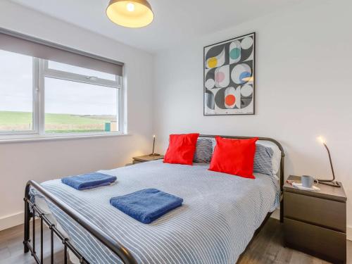 Marhamchurchにある3 Bed in Widemouth Bay 86151のベッドルーム1室(赤い枕のベッド1台、窓付)
