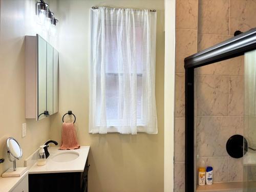 a bathroom with a shower and a sink and a mirror at Nintendo, Filtered H2O, Cafe, Central, Self-Check in Troy