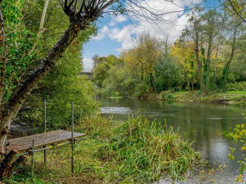 a wooden bench sitting next to a river at 1 Bed in Fordingbridge 89512 in Fordingbridge