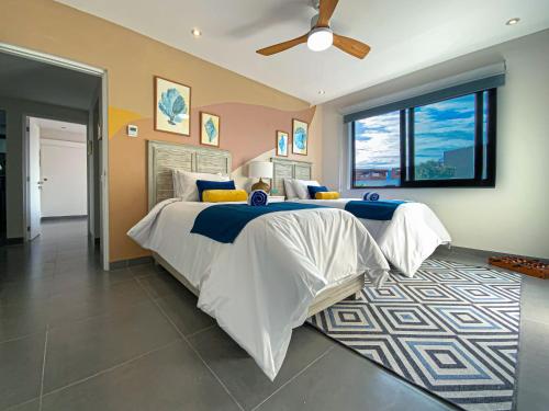 a bedroom with a large bed and a ceiling fan at Apartment with Private Terrace, Pool and Beach Club Access in Playa del Carmen