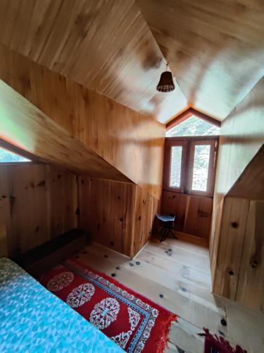 a bedroom with a bed in a wooden room at GHNP TRAILS Homestay in Gushaini