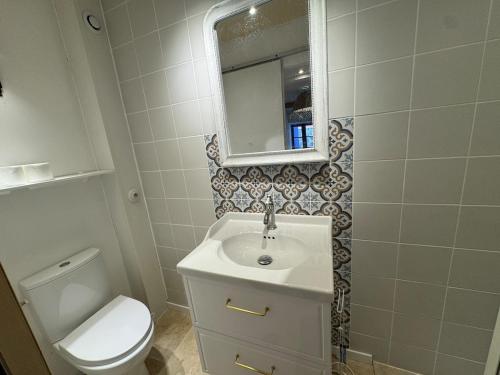 une salle de bain avec un lavabo, des toilettes et un miroir dans l'établissement Casa Jueliatte, à Collioure