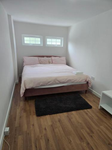 a bedroom with a bed and a wooden floor at Orlando in Thamesmead