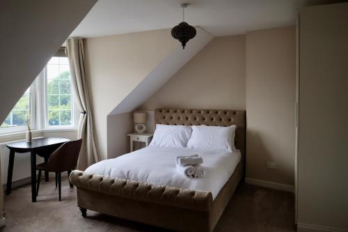 a bedroom with a bed and a table and window at Harbourside Hotel in Irvine