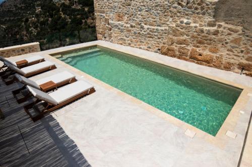 a swimming pool with two lounge chairs and a swimming pool at Villa Fragkaki in Oítilon