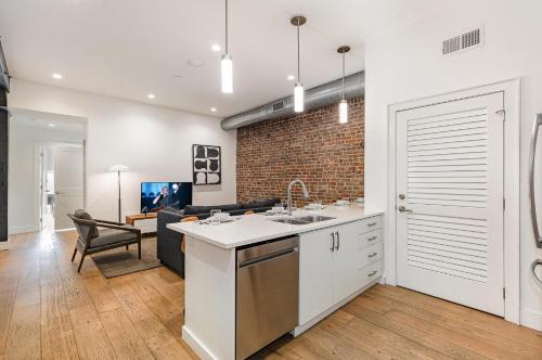 a kitchen with a sink and a living room at The Saddlery-Tracklist-2 Units-Walk to Broadway in Nashville