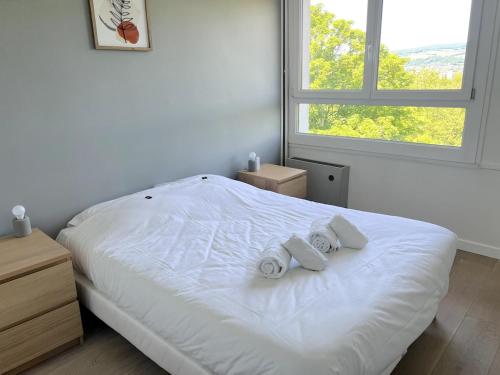 une chambre avec un lit blanc avec deux serviettes dessus dans l'établissement Annecy - Bright & renovated 3-room apartment, à Annecy
