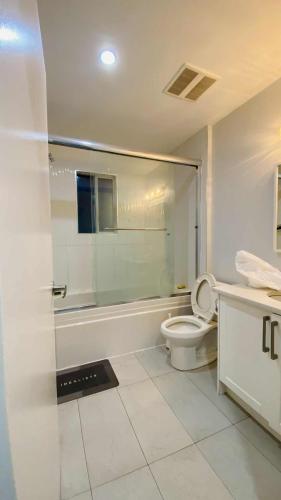 a white bathroom with a toilet and a shower at Cozoro 3 BEDROOMS Centre Vancouver in Vancouver