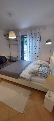 1 cama grande en un dormitorio con 2 luces en Rose Apartments, en Ičići