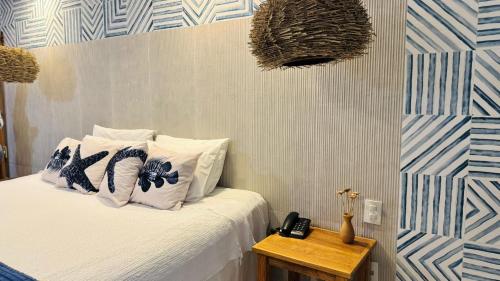 a bedroom with a bed with blue and white walls at Hotel Praia do Sol in Ilhéus