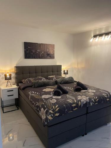 a large bed in a bedroom with two lamps at Second home apartment - rose gold in Kustići