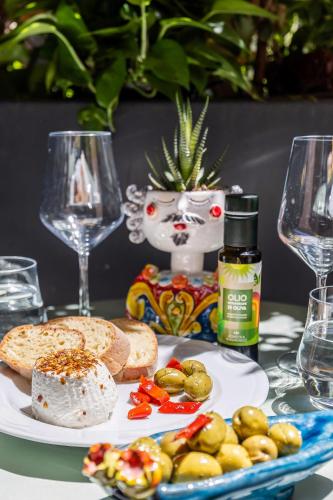a table with a plate of food and two wine glasses at Creuza De Ma in Riposto