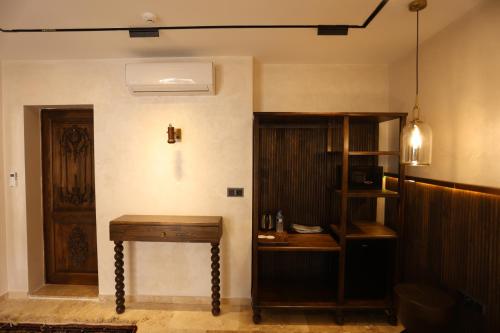 a room with a wooden table next to a door at Erdu Cappadocia Stone House in Avanos