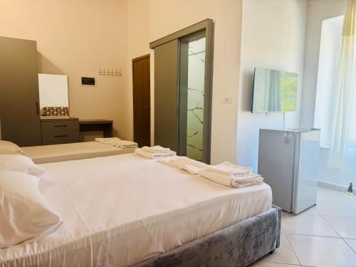 a bedroom with two beds and a glass door at Petros rooms in Himare