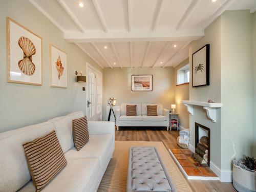 a living room with a white couch and a fireplace at Beaches in Overstrand
