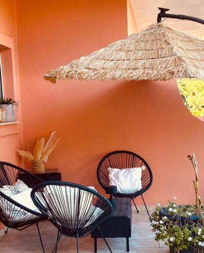 a patio with three chairs and an umbrella at KIPOS-SS residences in Dassia
