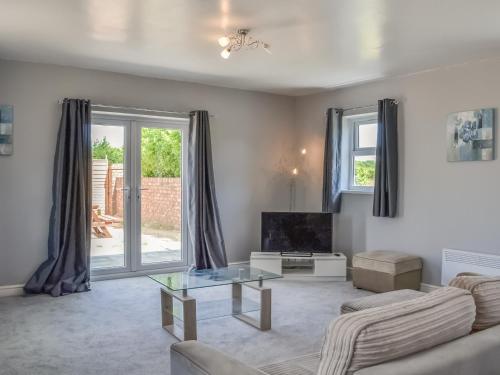 a living room with a couch and a tv at Dotterel Cottage - Uk39264 in Reighton