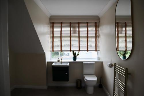 a bathroom with a sink and a toilet and windows at Harbourside Hotel in Irvine