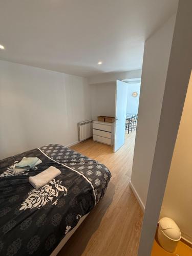 une chambre avec un lit avec une couverture noire et blanche dans l'établissement Appartement indépendant Chez Amel & Rémi, à Fabrezan