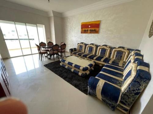 a room with four beds and a table and chairs at Bel appartement avec piscine vue mer & golf in Asilah