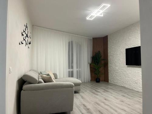 a living room with a couch and a tv at Garden Lake Apartment in Peschiera del Garda