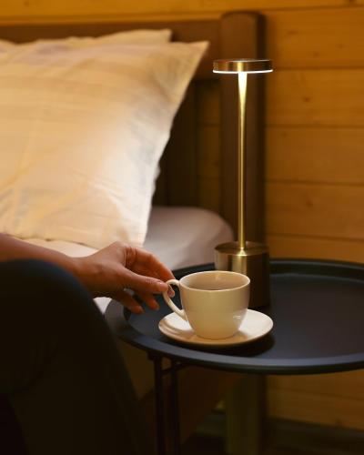 a person holding a coffee cup on a table with a lamp at OXYGEN utsera in Utsera