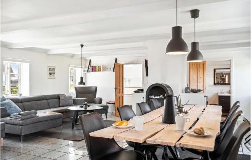 a kitchen and living room with a wooden table and chairs at Beautiful Home In Thyborøn With Sauna in Thyborøn