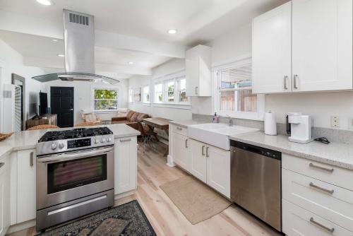 a kitchen with white cabinets and a stove top oven at Modern Gem in North Park in San Diego