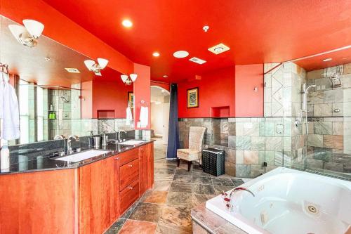 a large bathroom with two sinks and a tub at Iconic Downtown Colorado Springs Penthouse with 2000 Sq Ft Rooftop Deck, 10 Person Hot Tub and Stunning Mountain Skyline Views, Two Fireplaces, and Two Lavish Primary Suites in Colorado Springs