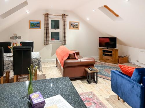 a living room with a couch and a tv at Bankfield Barn in Tideswell