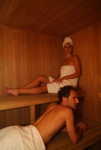 a man and a woman sitting in a sauna at Hotel Charleston in Spoleto