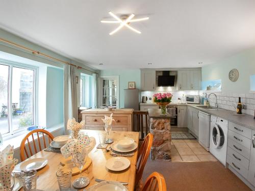 a kitchen with a table with chairs and a dining room at Cherry Tree Cottage - Uk46659 in Cheddar